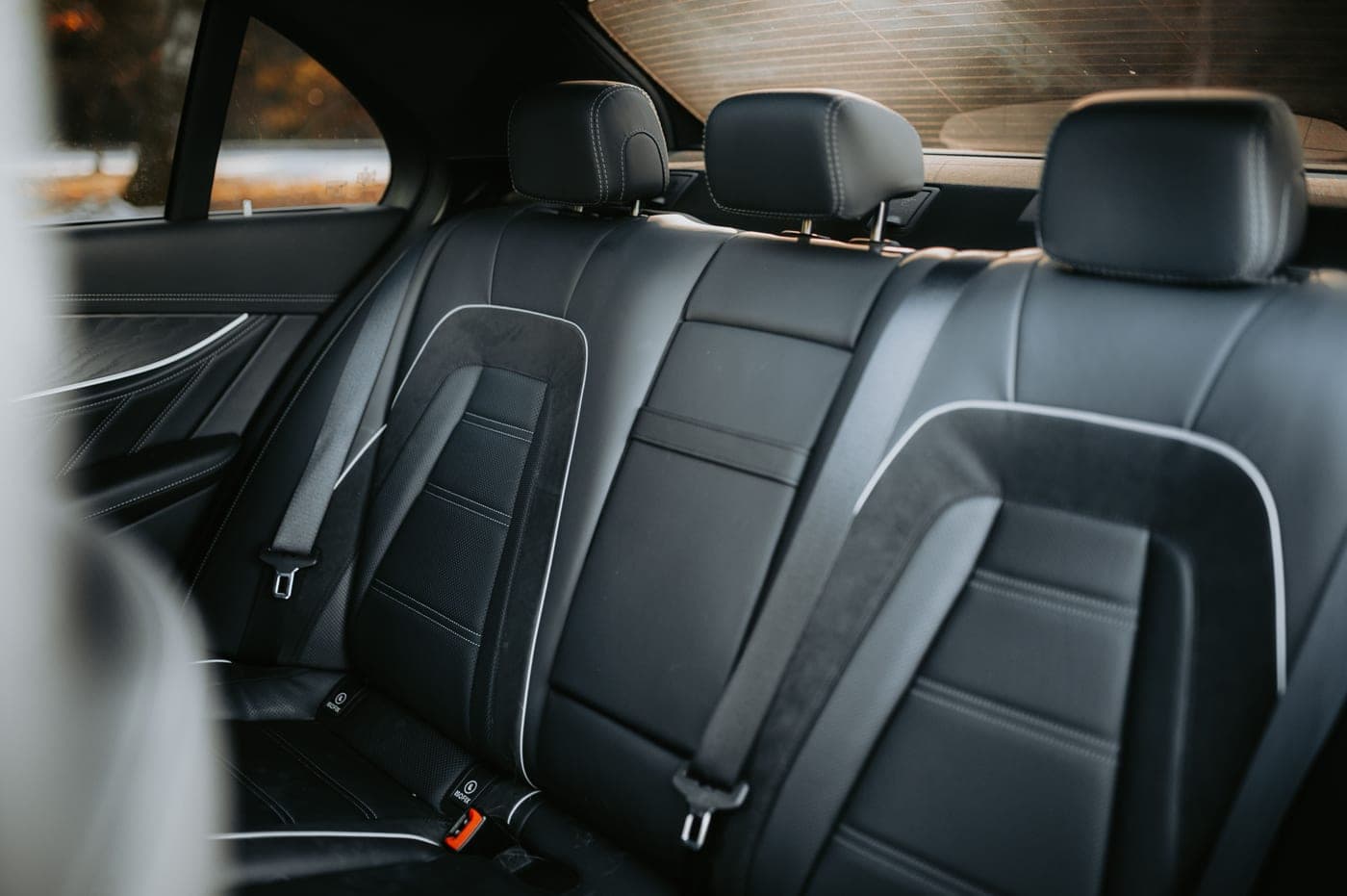 The cluttered back seat and floor of a used car